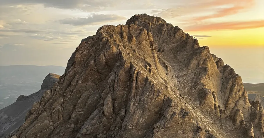A rocky summit ridge of Olympus in warm light above the tree line